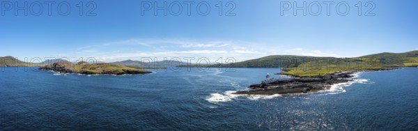 An aerial panorama of the coastal landscape of the Iveragh Peninsula with Beginish and Valentia Island Lighthouse