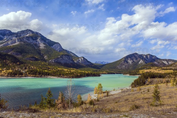 Lush multicolor autumn in the Canadian Rockies. The valley and azure icy water of the Kananaskis river. The concept of active, ecological and photo tourism