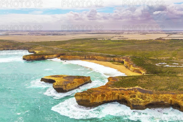Helicopter flight over the scenic Pacific coastline. The fabulous journey to Australia. Cloudy cool summer day. Legendary cliffs Twelve Apostles in the snow-white foam of the ocean surf