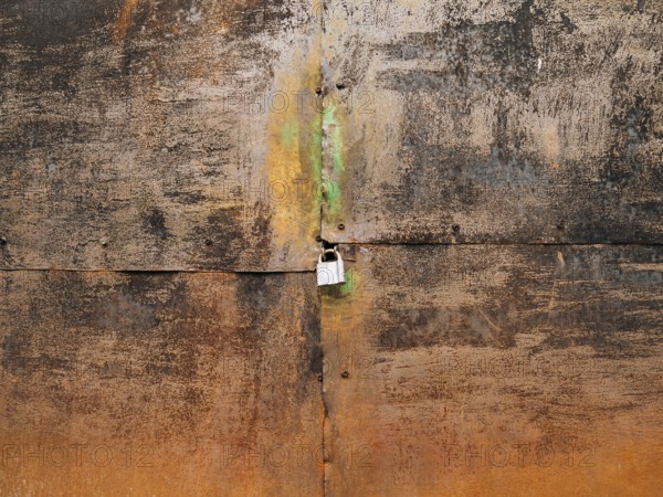 Metal rusty gate and padlock. Texture of rusty metal