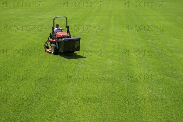 Mowing grass at the football stadium in Lubin, Poland, Europe