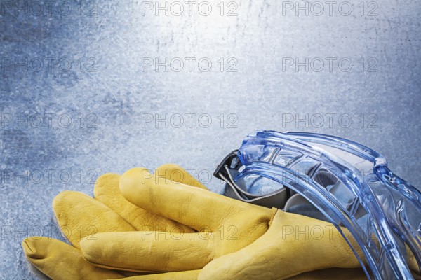 Set of safety goggles gloves on metallic background construction concept