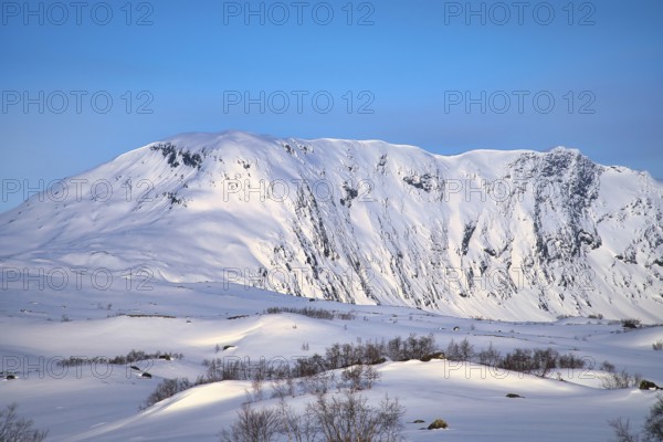Norwegian high mountains in the snow. Mountains covered with snow. Snow-covered landscape in Scandinavia
