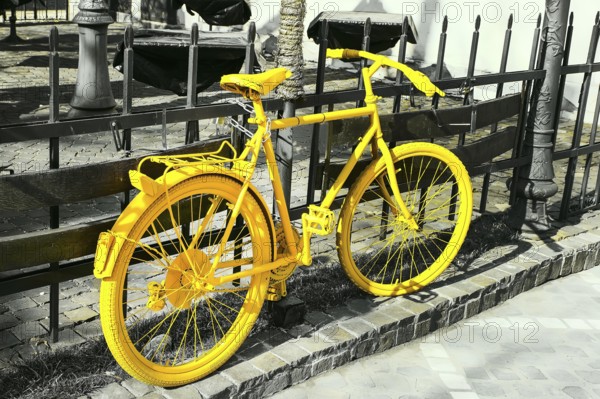 Colorful vibrant yellow color bicycle on the gray monochrome background