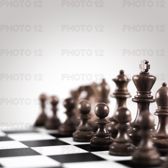 Strategy and tactics concept, black wooden chess figures on the board standing in a row ready for game