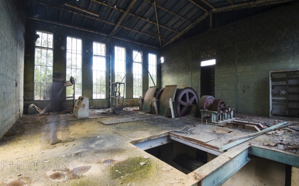 Interior of a deserted abandoned factory with human shade walking