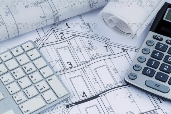 An architect's construction plan with a calculator. Symbolic photo for financing and planning a new house. Austria