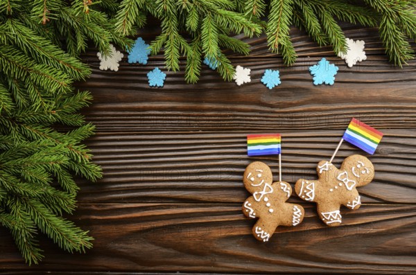 Christmas background of gingerbread man with flag spruce branches and colorful sugar snowflakes on wooden table