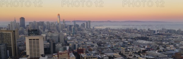 Orange hues seem to bounce off the tallest building as night comes to the San Francisco Bay area