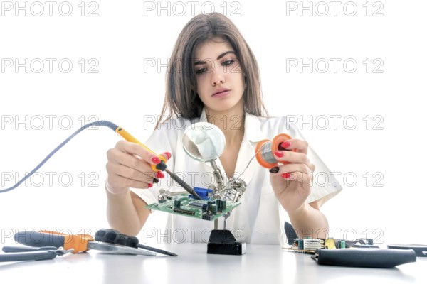 Woman Electronic Technician Repair Electronic Equipment using Electric Soldering Iron