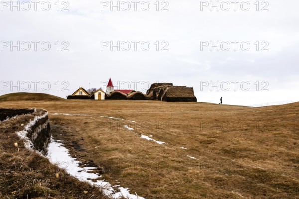 An expansive landscape with a church and traditional buildings in the background, Iceland, Europe