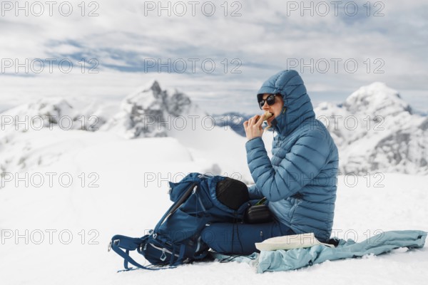 Mountaineer backcountry ski touring in the mountains. Ski touring in high alpine landscape with snowy trees. Adventure winter extreme sport.