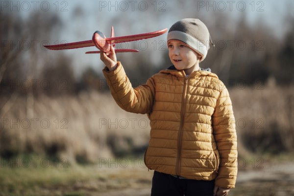 Young boy plays with toy plane