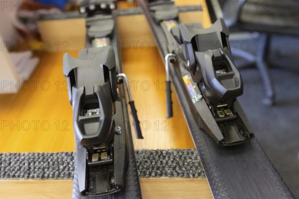Ski center repair service shop, adjust the bindings and boots equipment on the table. Winter rent and sale