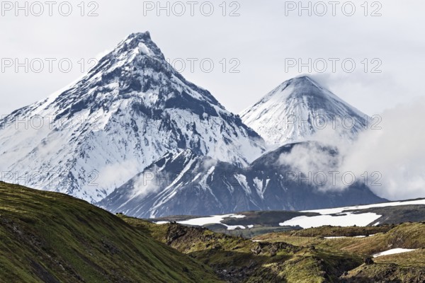 Nature of Kamchatka Peninsula, beautiful volcanic landscape: view on Kamen Volcano, active Klyuchevskoy Volcano and active Bezymianny Volcano. Russia, Far East, Kamchatka