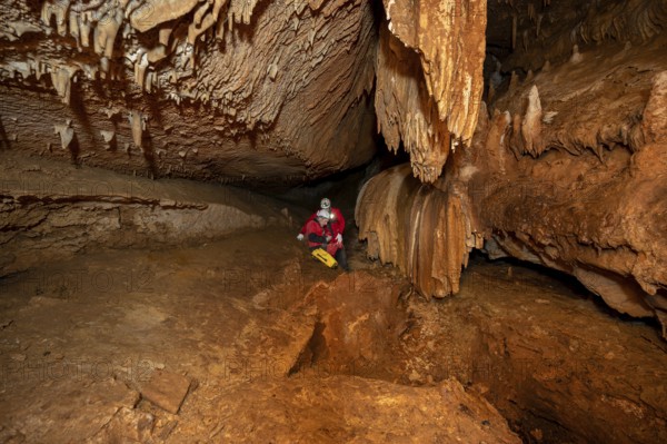 A group of speleologist inside a cave, illuminated by headlamps, exploring the depths of a mysterious underground system. graphy