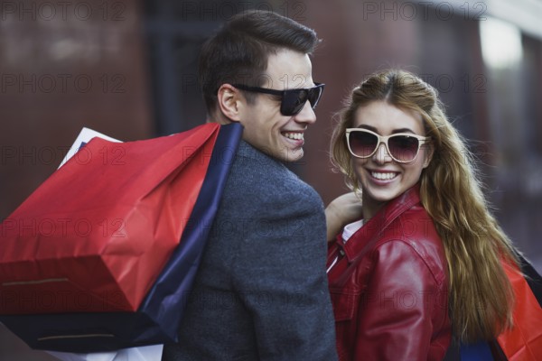 Picture showing young couple shopping in the city. Portrait of a couple with shopping bags in the city.People, sale, love and happiness concept