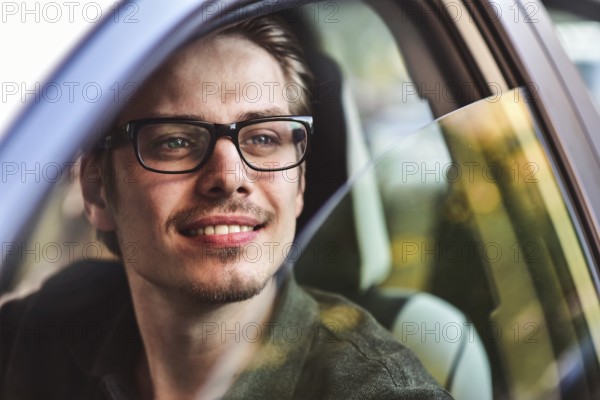 Enjoy the drive. Image of young handsome guy sitting in car