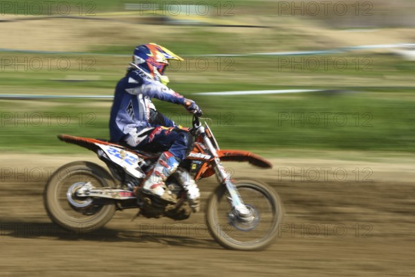 Unrecognized athlete riding a sports motorbike on a motocross racing event. Exreme sports high speed
