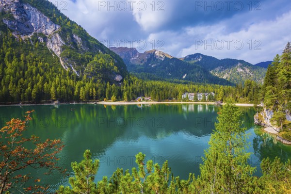 Green water reflects the surrounding mountains and forest. Magnificent lake Lago di Braies. South Tyrol, Italy. The concept of walking and eco-tourism