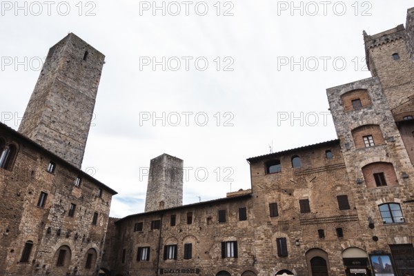 Low angle view of the medieval buildings and a bell tower of a small village in the mountains in Tuscany
