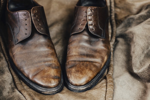 A pair of worn brown leather shoes with a vintage and rustic aura
