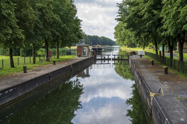A lock on a quiet canal with a boat and trees on the banks, Dortmund-Ems Canal, Emsland, Lower Saxony