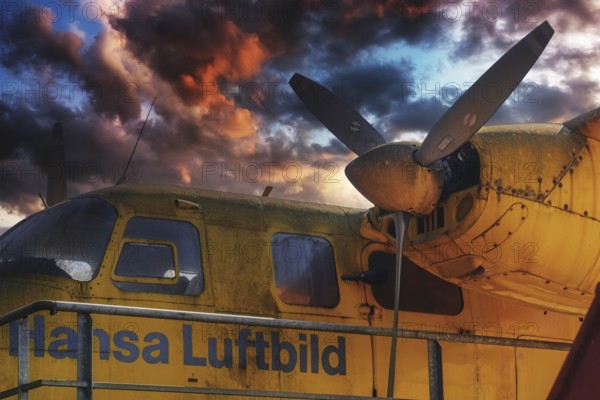 Old yellow aeroplane with propeller and a dramatic cloudy sky at sunset, Aero Commander 680E Commander, D-IBIB, Babbenhausen, Bad Oeynhausen, North Rhine-Westphalia, Germany, Europe