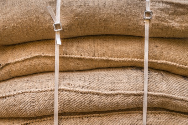 Close-up image of jute sacks filled with goods, piled upon each other and tied up, ready for transportation