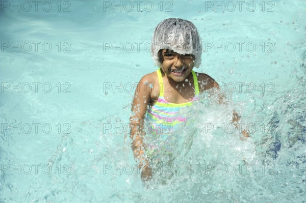 Little girl splashing water in swimming pool, Raigad, Maharashtra, India, Asia, MR#736LA, Asia