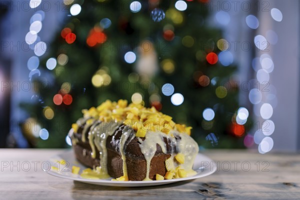 Christmas stollen stands on a plate on a wooden table.
