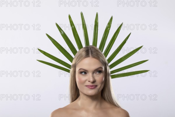 A creative portrait of a woman adorned with vibrant green leaves, symbolizing harmony between nature and beauty