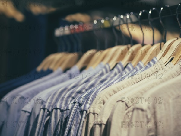 Close up view of man clothes hang in clothes store. Hangers with different male clothes. Copy space. Selective focus. Toned image