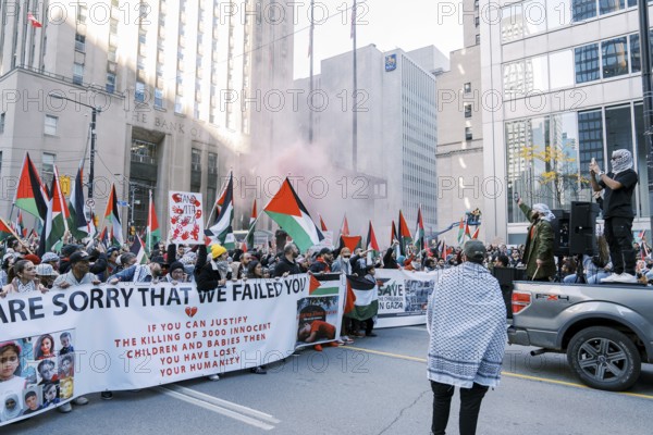 Toronto, Canada - 28 October 2023: Anti-war march in Toronto by Palestinians against Israel's aggression in Gaza. City's peaceful protest against Israel-HAMAS war. Protesters wave flags