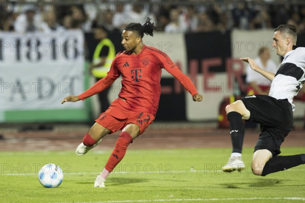 Football match, Michael Akpovie OLISE FC Bayern Munich left, crossing the ball, Niklas KOLBE SSV Ulm tries to stop him with a dive, Donaustadion football stadium, Ulm, Germany, Europe