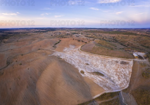 Drone aerial panorama of a desert like hill landscape with marble stones dust at sunset in Terena, Portugal, Europe