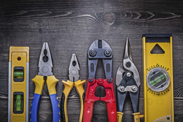 Tin snips steel cutter pliers construction level on wooden board