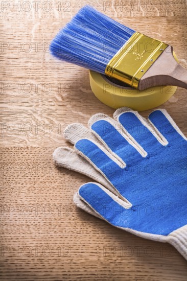 Safety gloves duct tape with paintbrush on wood board maintenance concept