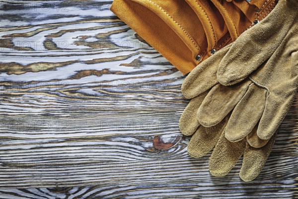 Leather protective gloves building belt on wooden board