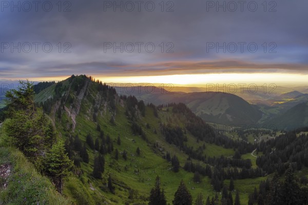 Panoramic view of a light and weather scene over the foothills of the Alps, taken from the Nagelfluhkette, Allgäu. On the right in the background Oberstaufen and on the left the Seelekopf