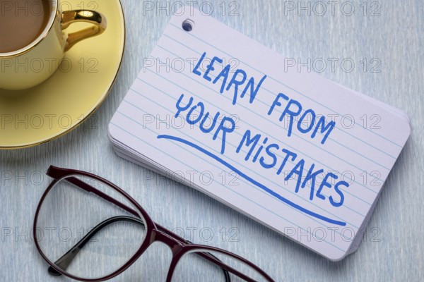 Learn from your mistakes - reminder on a stack of index cards with a cup of coffee, learning, determination and perseverance concept