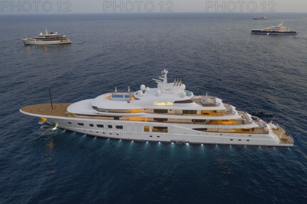 Aerial view of 104 metre motor yacht QUANTUM BLUE, delivered in 2014 by the German shipyard Lürssen Yachts, anchored off the Principality of Monaco, Mediterranean Sea, shortly after sunset