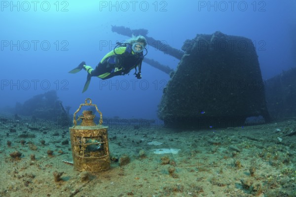 Diver finds lamp in front of 8-inch twin gun on USS Saratoga, Marshall Islands, Bikini Atoll, Micronesia, Pacific Ocean, Oceania