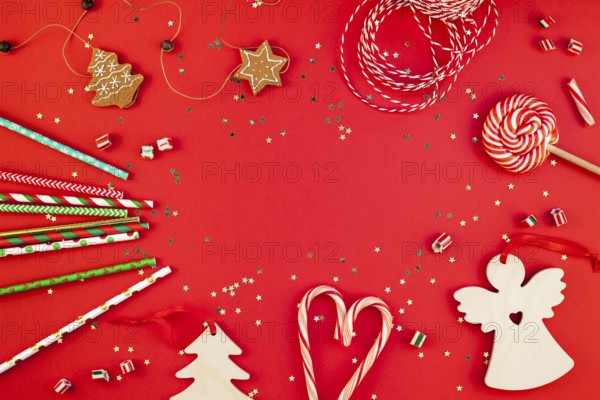 New Year or Christmas decoration flat lay top view Xmas holiday celebration handmade decor wooden toys sweets golden stars glitter on red paper background. Template frame for greeting card your design