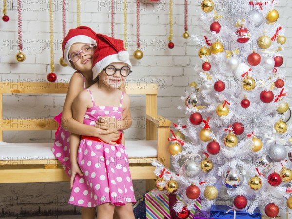 Two funny sisters four girls and six years of playing and having fun in the home New Years interior