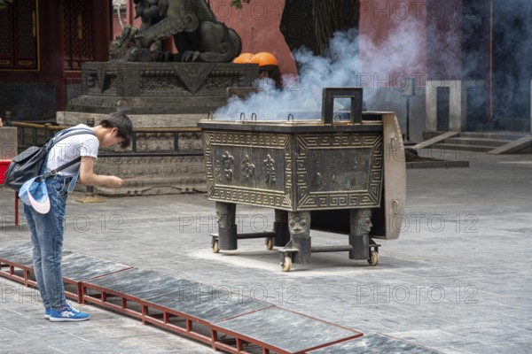 Beijing, China, June 8 2018 : Religious man praying at the Lama temple which is the biggest Tibetan Buddhist temple in Beijing, China, Asia