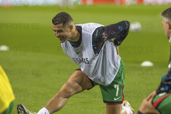 Football match, Cristiano RONALDO CR7 Portugal kneeling during pre-match warm-up with right leg and with left leg stretched out, showing teeth and looking down with concentration, Estadio do Dragao, Porto, Portugal, Europe