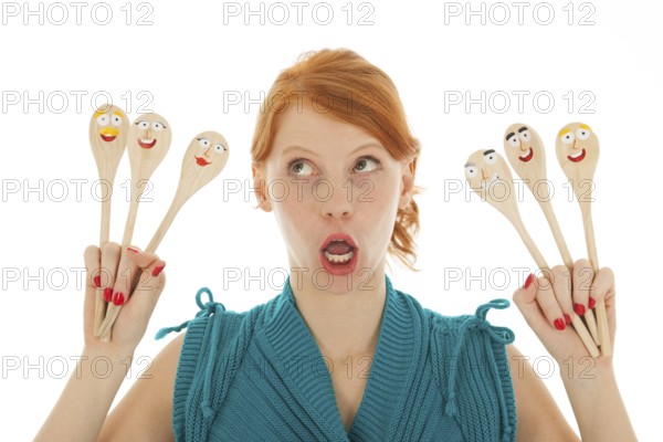 Woman cooking with funny wooden spoons