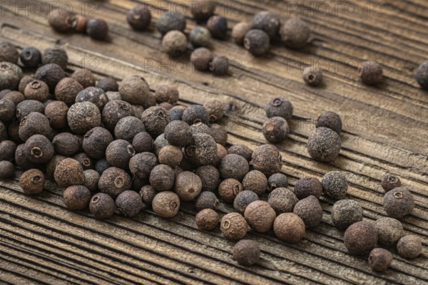 Allspice spice on dark rustic wooden background