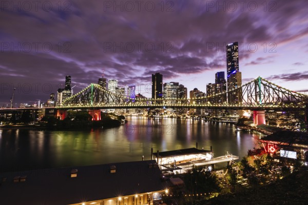 BRISBANE, AUSTRALIA, JULY 27, 2023: Brisbane skyline and Story Bridge from the suburb of New Farm and Wilson Outlook Reserve at dusk in Queensland, Australia, Oceania